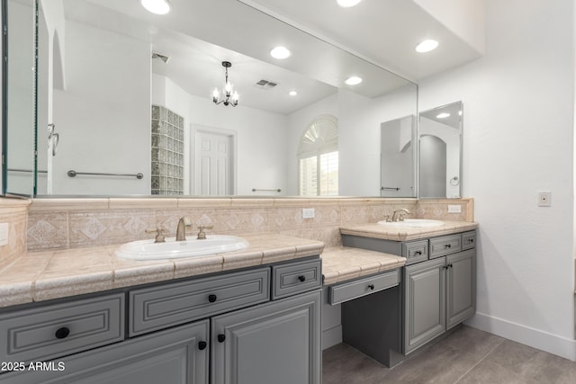 4711 E Buckboard Ct, Gilbert, AZ 85297 - full bath featuring double vanity, backsplash, a chandelier, tile patterned floors, and baseboards