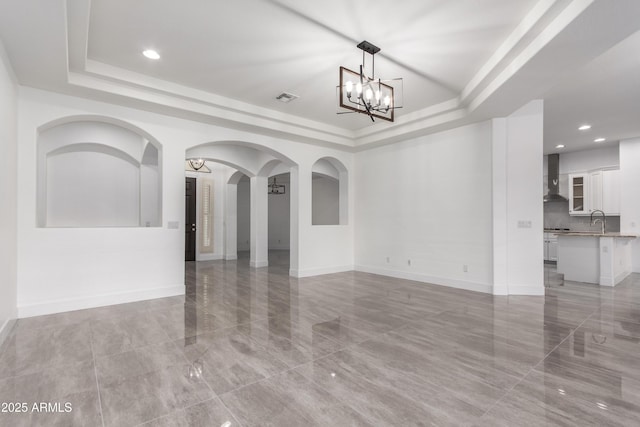 4711 E Buckboard Ct, Gilbert, AZ 85297 - empty room with a raised ceiling, a chandelier, a sink, arched walkways, and recessed lighting