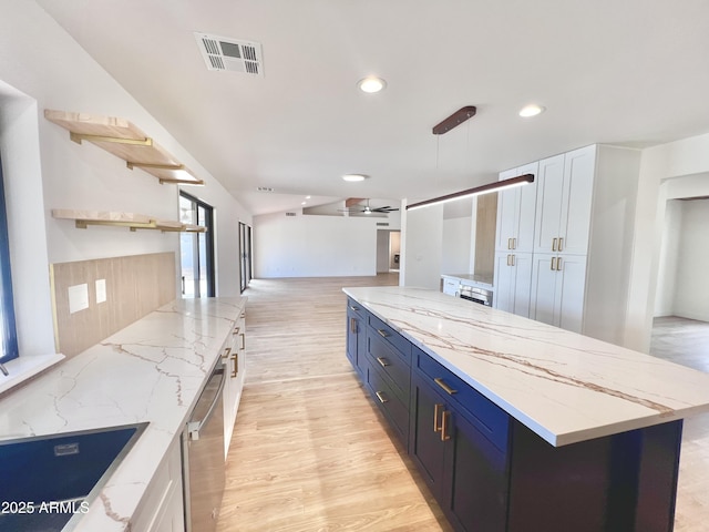 kitchen with white cabinetry, pendant lighting, light hardwood / wood-style floors, and light stone counters