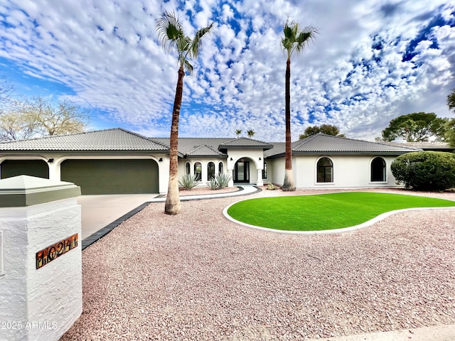 mediterranean / spanish home with a front lawn and a garage