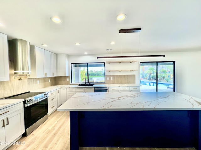 kitchen featuring white cabinetry, appliances with stainless steel finishes, decorative light fixtures, light hardwood / wood-style flooring, and light stone counters