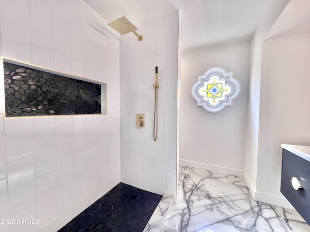 bathroom featuring tiled shower and vanity