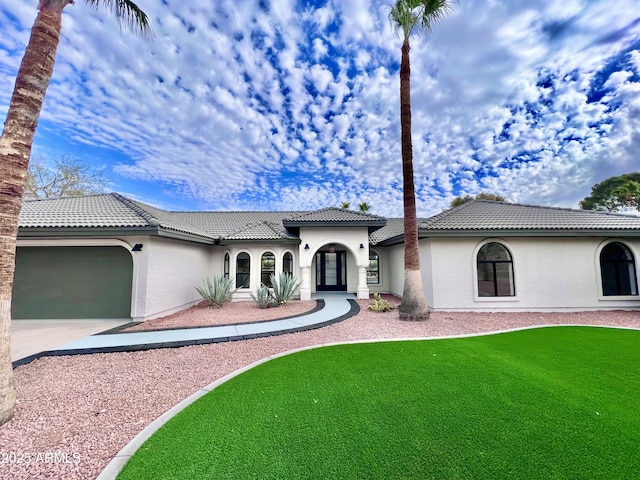 mediterranean / spanish home with a front yard and a garage