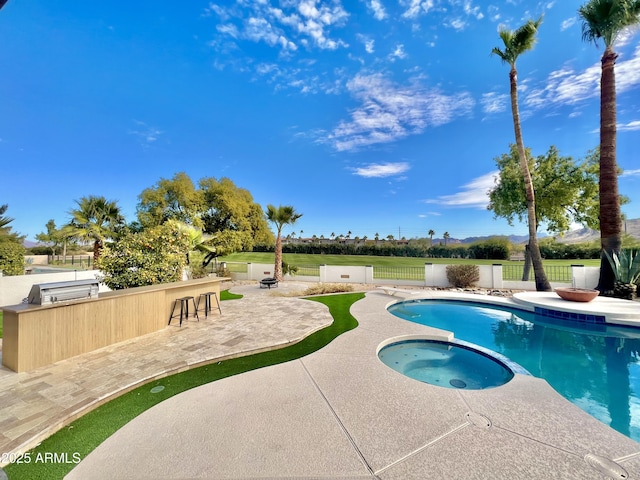 view of pool featuring a patio area, a bar, and an in ground hot tub