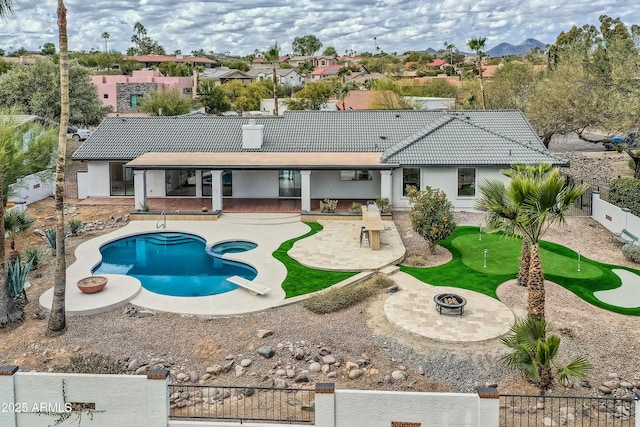 back of house featuring a fenced in pool, a patio, and a fire pit