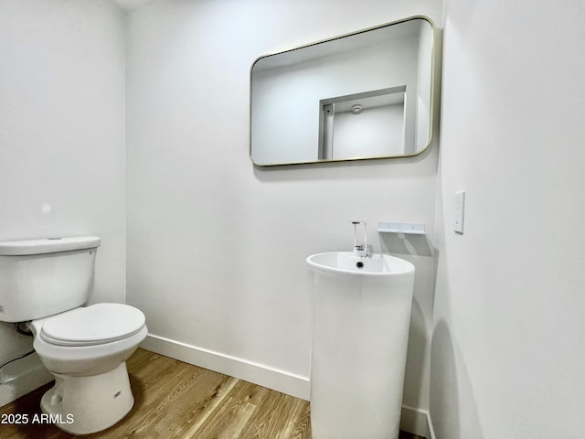 bathroom with wood-type flooring and toilet