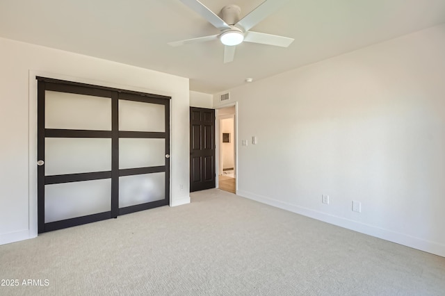 unfurnished bedroom with ceiling fan, light colored carpet, and a closet