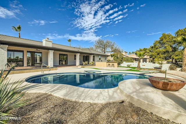 view of pool with a hot tub, ceiling fan, an outdoor bar, and a patio