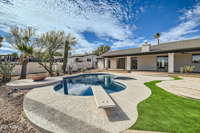 view of swimming pool featuring a diving board, a hot tub, and a patio