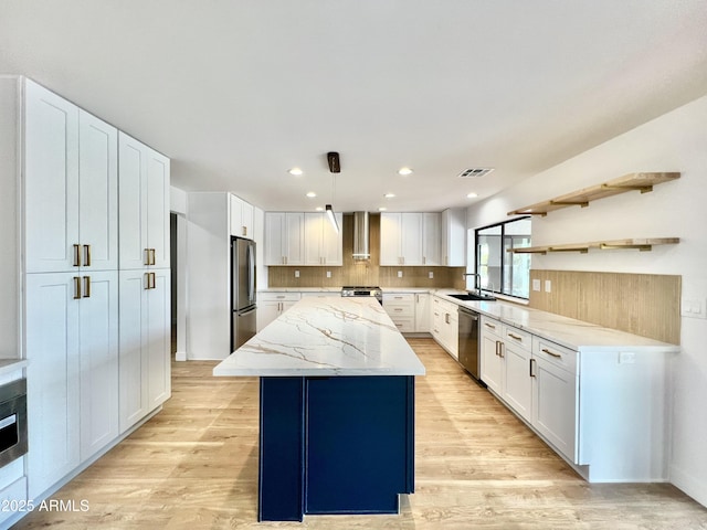 kitchen with white cabinetry, appliances with stainless steel finishes, a kitchen island, pendant lighting, and sink