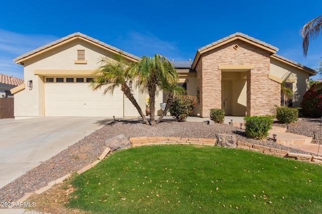 view of front of property featuring an attached garage, stone siding, driveway, roof mounted solar panels, and a front yard