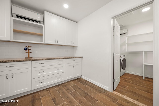 laundry area with separate washer and dryer, dark hardwood / wood-style floors, and a wall mounted AC