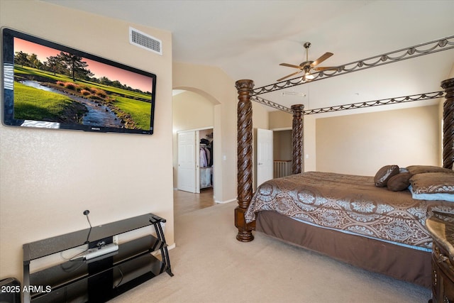carpeted bedroom featuring arched walkways, vaulted ceiling, visible vents, and baseboards