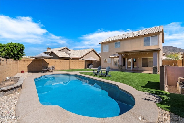 view of swimming pool featuring a fenced backyard, a patio, and a lawn