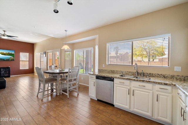 kitchen featuring ceiling fan, dishwasher, a sink, baseboards, and white cabinetry