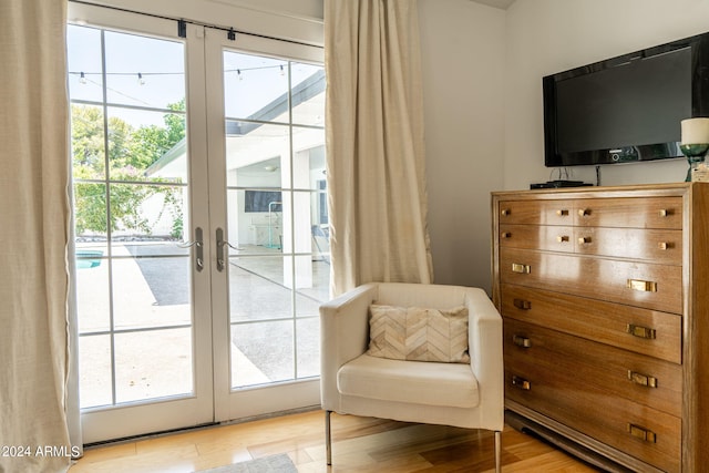 living area with french doors and light wood-type flooring