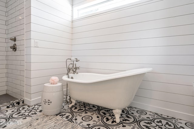 bathroom with a washtub and tile patterned floors