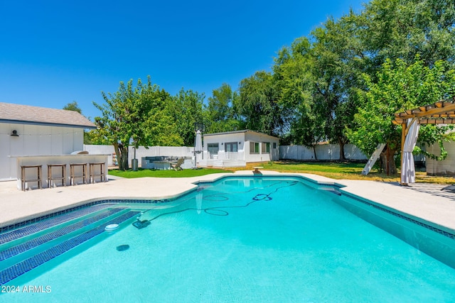 view of pool featuring a pergola, a yard, a patio, an outbuilding, and exterior bar