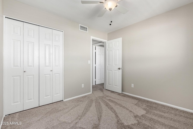 unfurnished bedroom with carpet floors, a ceiling fan, visible vents, baseboards, and a closet