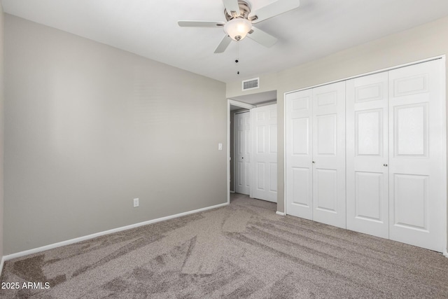 unfurnished bedroom with baseboards, visible vents, ceiling fan, carpet floors, and a closet