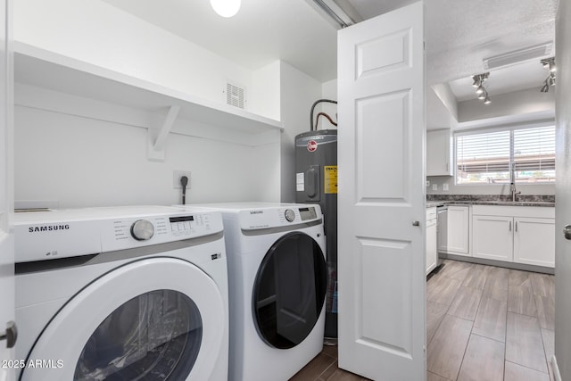 laundry room with wood tiled floor, laundry area, visible vents, and washer and clothes dryer