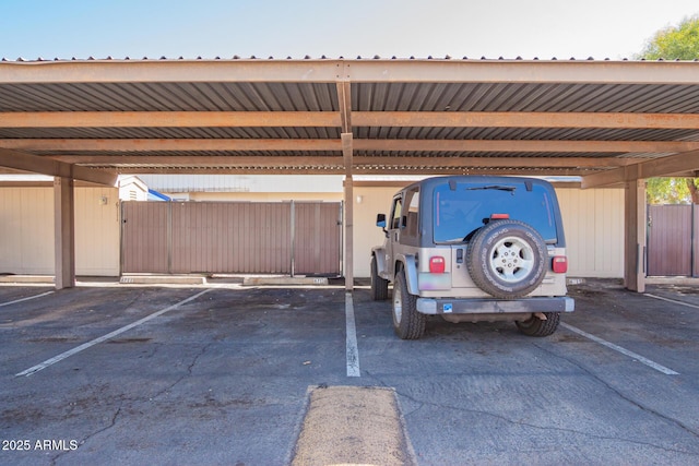 covered parking lot featuring fence