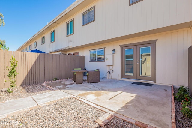 rear view of house featuring a patio, french doors, and fence