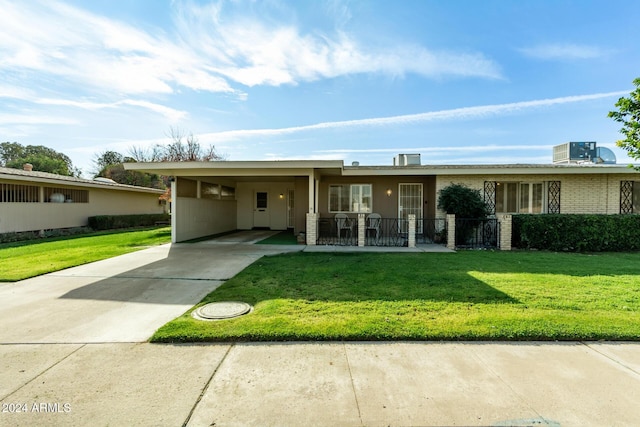 view of front facade with a front lawn, a porch, and a carport