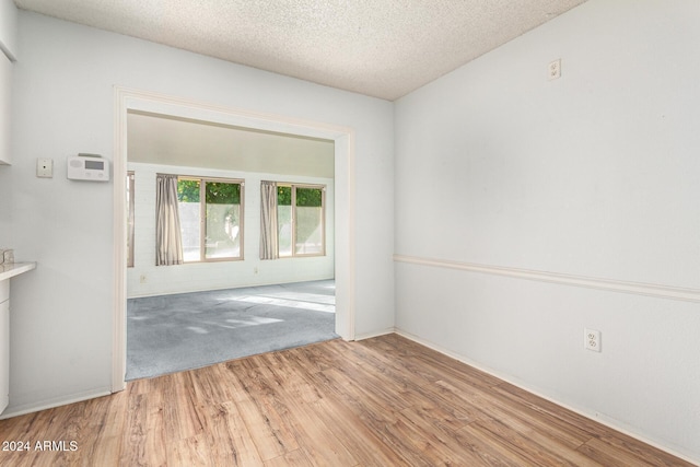 unfurnished room featuring hardwood / wood-style floors and a textured ceiling