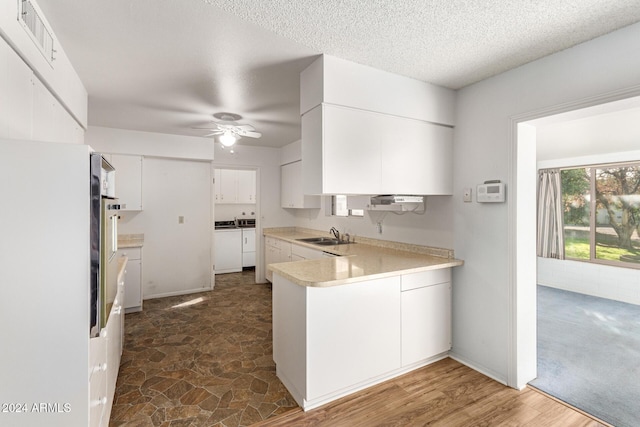 kitchen with washer and clothes dryer, ceiling fan, white cabinets, and sink