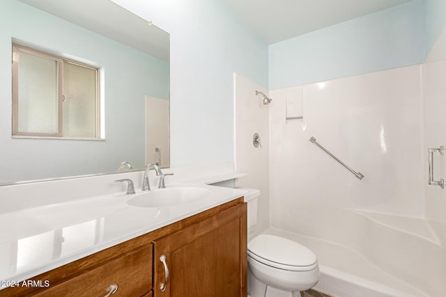 bathroom featuring vanity, toilet, and walk in shower