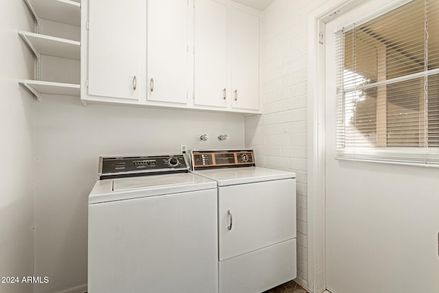 laundry area with washing machine and clothes dryer and cabinets