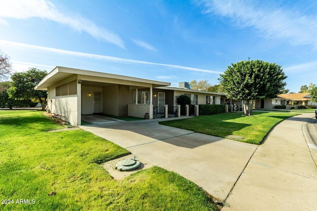 ranch-style home featuring a carport and a front lawn