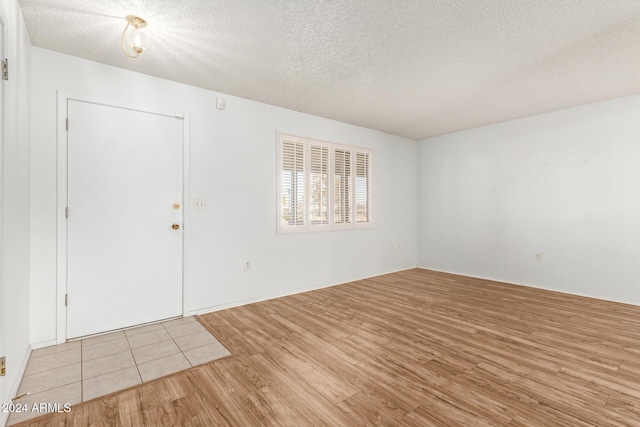 foyer with light hardwood / wood-style floors and a textured ceiling