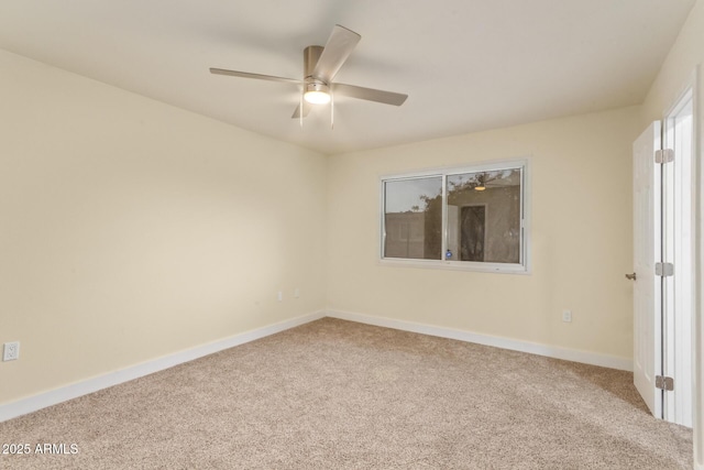 carpeted empty room featuring ceiling fan and baseboards