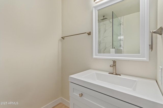 full bath with baseboards, a walk in shower, and vanity