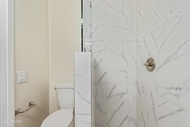 full bath featuring toilet and a marble finish shower