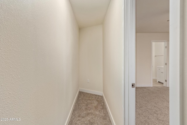 hallway featuring carpet floors and baseboards