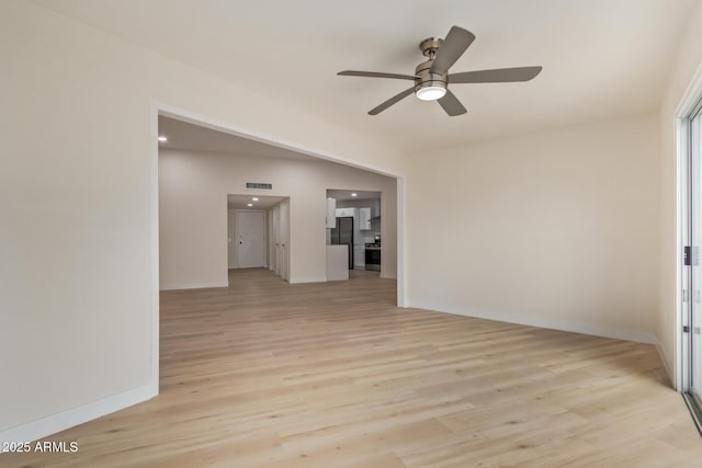 unfurnished room with light wood finished floors, ceiling fan, and baseboards