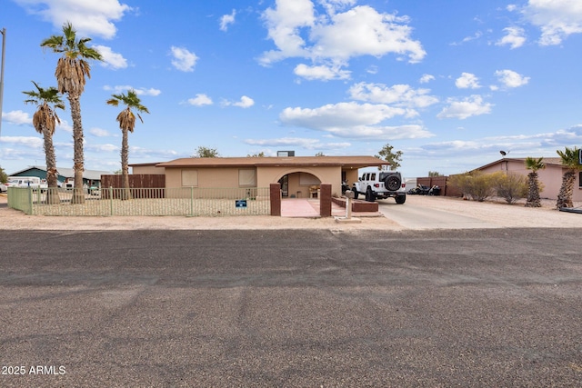 view of front of home featuring a fenced front yard, driveway, and stucco siding