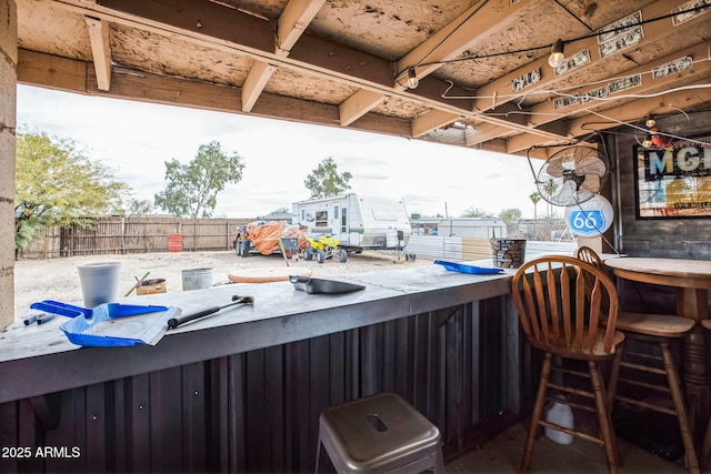 view of patio featuring outdoor dry bar and fence