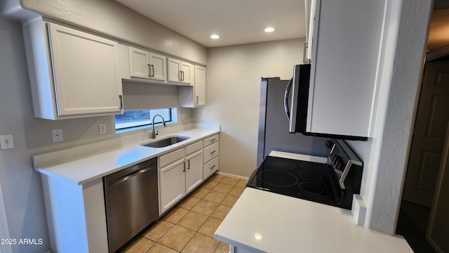 kitchen with electric range, dishwasher, sink, light tile patterned floors, and white cabinets