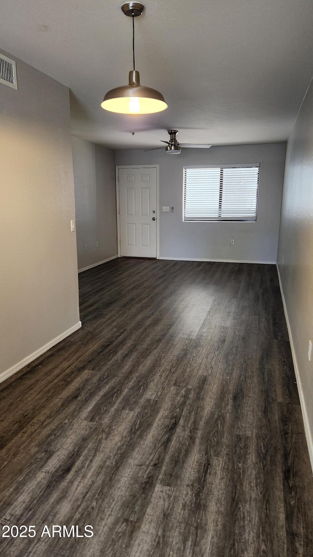 unfurnished room with ceiling fan and dark wood-type flooring