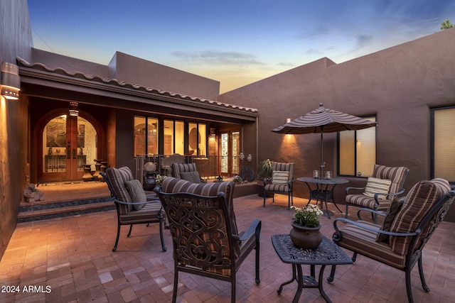 patio terrace at dusk with an outdoor hangout area and french doors