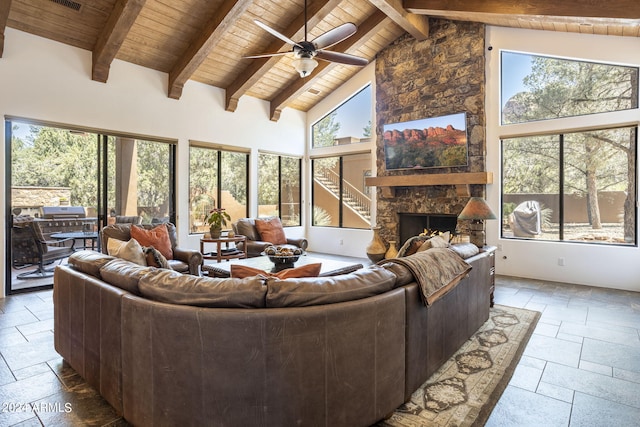 living area featuring wood ceiling, a fireplace, high vaulted ceiling, and stone tile flooring