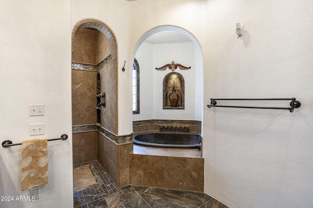 full bathroom featuring a garden tub and a tile shower