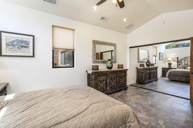 bedroom with lofted ceiling, stone tile flooring, and visible vents