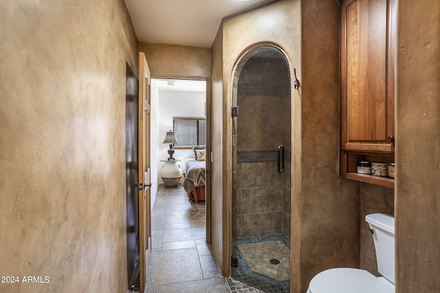 ensuite bathroom with a stall shower, toilet, ensuite bath, and stone tile floors