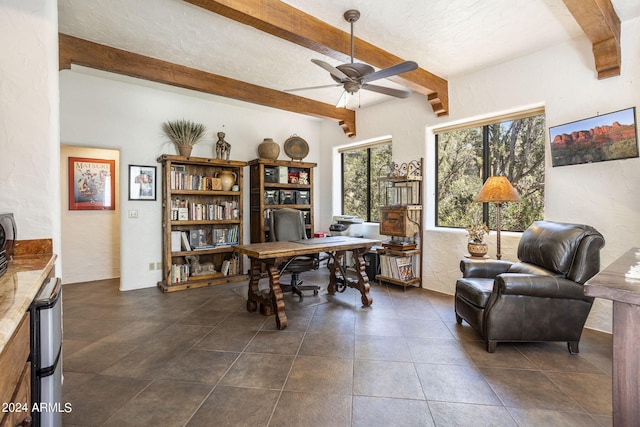 home office featuring a textured ceiling, a textured wall, dark tile patterned floors, a ceiling fan, and beamed ceiling