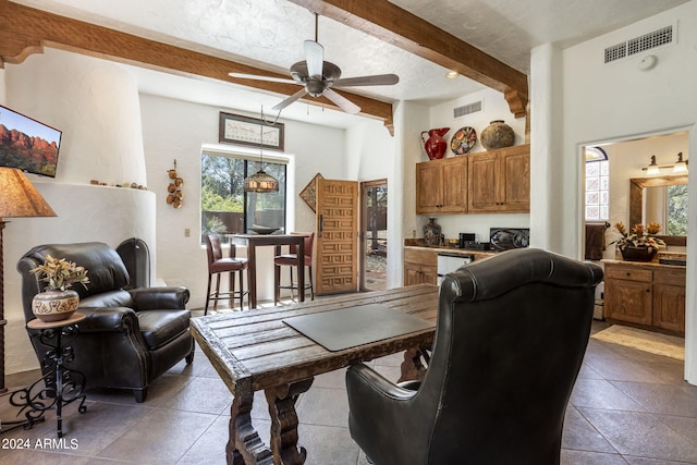 interior space featuring a ceiling fan, a textured ceiling, visible vents, and beamed ceiling